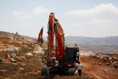 Heavy machinery work on a field as they begin construction work of Amichai, a new settlement which will house some 300 Jewish settlers evicted in February from the illegal West Bank settlement of Amona, in the West Bank, June 20, 2017. PHOTO BY REUTERS/Ronen Zvulun
