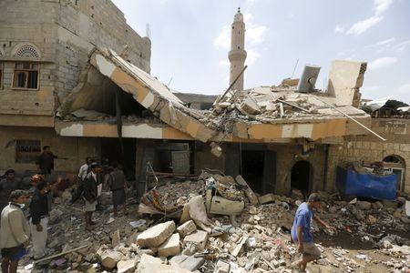 People walk at the site of a Saudi-led air strike in Yemen's capital Sanaa, September 21, 2015. PHOTO BY REUTERS/Khaled Abdullah