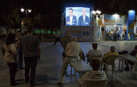 People watch a live televised debate between Former primer minister and leftist Syriza party leader Alexis Tsipras and the conservative New Democracy leader Vangelis Meimarakis, in Syntagma Square in the center of Athens, Greece, September 14, 2015. PHOTO BY REUTERS/Paul Hanna