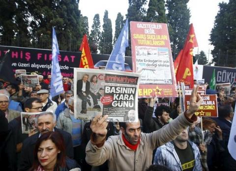 A demonstrator holds newspaper read "Black day of the press" during a protest outside the Cumhuriyet newspaper in Istanbul, Turkey, November 27, 2015. PHOTO BY REUTERS/Osman Orsal