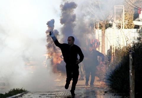 A Kurdish demonstrator throws a tear gas canister back at riot police during a protest against the curfew in Sur district in the southeastern city of Diyarbakir, Turkey, December 22, 2015. PHOTO BY REUTERS/Sertac Kayar