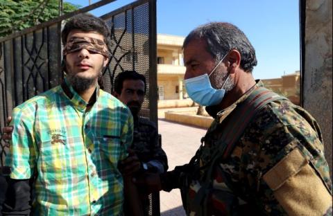 Members of Syrian Democratic Forces escort a blindfolded civilian detainee suspected to be a member of Islamic State militants in Raqqa, Syria, October 12, 2017. PHOTO BY REUTERS/Issam Abdallah