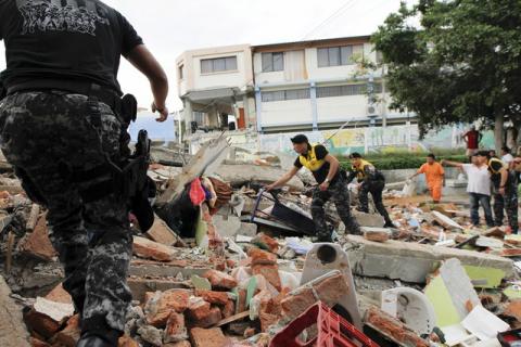 Red Cross members, military and police officers work at a collapsed area after an earthquake struck off Ecuador's Pacific coast, at Tarqui neighborhood in Manta, April 17, 2016. PHOTO BY REUTERS/Guillermo Granja