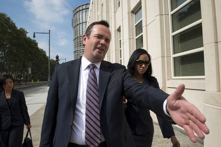 Edward O'Callaghan (C), a lawyer for Jeffrey Webb, makes his way past photographers as he departs the U.S. federal court with Webb's wife (R) in Brooklyn, New York July 18, 2015. PHOTO BY REUTERS/Stephanie Keith