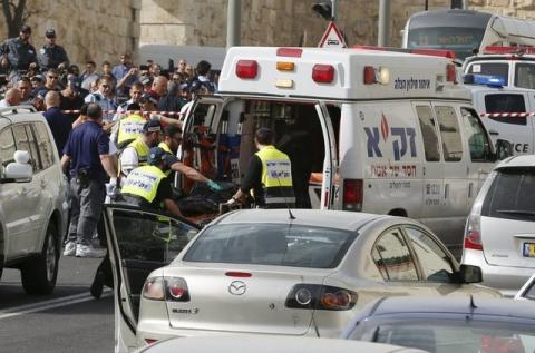 Israeli emergency personnel evacuate the body of one of the two Palestinian assailants whom police said carried out a drive-by shooting on a commuter bus in an east Jerusalem suburb before being shot dead by police opposite the Notre Dame Center just outside Jerusalem's Old City, March 9, 2016. PHOTO BY REUTERS/Ammar Awad