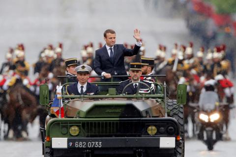 French President Emmanuel Macron waves as stands in the military command car on the Champs-Elysees to attend a ceremony at the Tomb of the Unknown soldier at the Arc de Triomphe in Paris, France, May 14, 2017. PHOTO BY REUTERS/Michel Euler