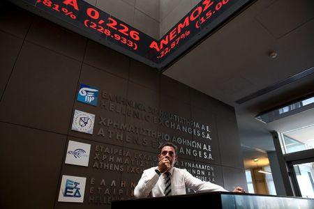 An employee looks on at electronic board displaying stock prices at the entrance of the Athens Stock Exchange, Greece, August 3, 2015. PHOTO BY REUTERS/Yiannis Kourtoglou