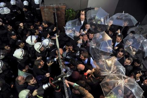 Employees block the door as riot police try to enter Kanalturk and Bugun TV building in Istanbul, Turkey, October 28, 2015. PHOTO BY REUTERS/Usame Ari