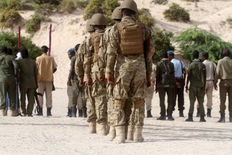 Somalia soldiers and policemen look on as Hassan Hanafi, a former media officer for the Somali Islamist group al Shabaab, stands tied to a pole before his execution by shooting at close range on a field in General Kahiye Police Academy in Somalia's capital Mogadishu, April 11, 2016. PHOTO BY REUTERS/Ismail Taxta