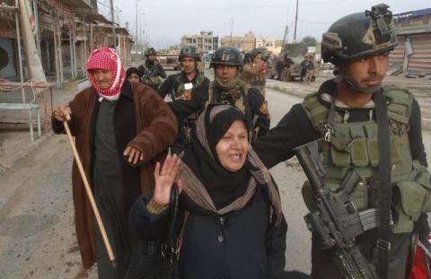 Civilians flee to a safe area with help from Iraqi security forces in Ramadi city, December 31, 2015. PHOTO BY REUTERS/Stringer