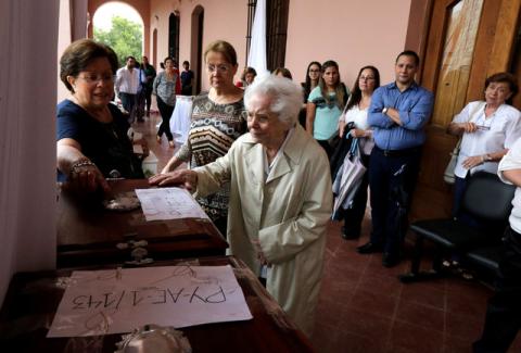 Family members approach the coffin of Miguel Angel Soler during a ceremony where the remains of persons who went missing during the dictatorship government of Alfredo Stroessner are returned in the Cultural Center of the Republic, Asuncion, Paraguay, February 10, 2017. PHOTO BY REUTERS/Jorge Adorno
