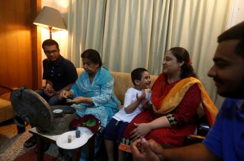 Rehana Khursheed Hashmi, 75 (2nd L) migrated from India with her family in 1960 and whose relatives, live in India, prepares pan (beetle leaf) while sitting with her grandsons and daughter in-law at her residence in Karachi, Pakistan, August 7, 2017. PHOTO BY REUTERS/Akhtar Soomro