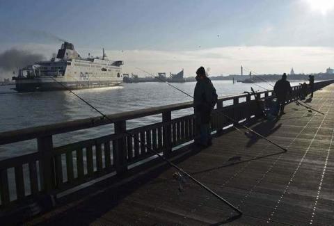 A Channel Ferry passes fishermen on Calais harbour wall as it arrives from Britain, in Calais, France, January 20, 2016. PHOTO BY REUTERS/Toby Melville