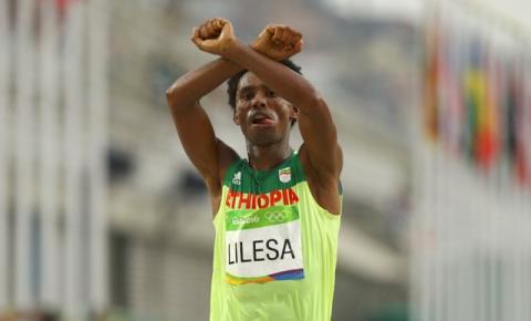 Feyisa Lilesa (ETH) of Ethiopia celebrates after the Final Men's Marathon in Rio de Janeiro, Brazil, August 21, 2016. PHOTO BY REUTERS/Athit Perawongmetha
