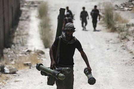 A fighter from the Free Syrian Army's Al Rahman legion carries a weapon as he walks towards his position on the frontline against the forces of Syria's President Bashar al-Assad in Jobar, a suburb of Damascus, Syria, July 27, 2015. PHOTO BY REUTERS/Bassam Khabieh