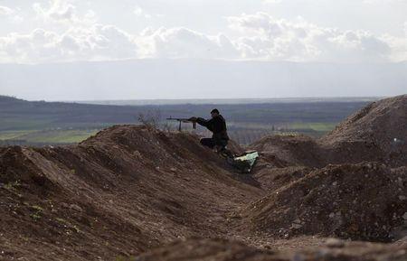 A rebel fighter from the Ahrar al-Sham Islamic Movement takes a position as he aims his weapon at Morek front line in the northern countryside of Hama, March 16, 2015. PHOTO BY REUTERS/Khalil Ashawi