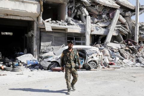 A fighter of the Syrian Democratic Forces guards a road at the frontline in Raqqa, Syria, October 5, 2017. PHOTO BY REUTERS/Erik De Castro