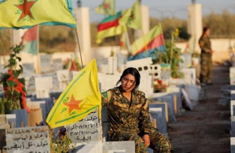 Fighters of Syrian Democratic Forces visit the graves of their late comrades at a cemetery for those fighters killed during fightings with Islamic State militants in Kobani, Syria, October 11, 2017. PHOTO BY REUTERS/Erik De Castro