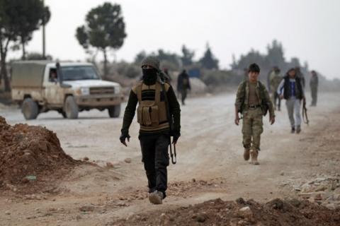 Free Syrian Army fighters carry their weapons as they walk on the outskirts of the Islamic State-controlled northern Syrian town of al-Bab, Syria, February 4, 2017. PHOTO BY REUTERS/Khalil Ashawi