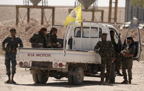 Fighters from Deir al-Zor military council which fights under the Syrian Democratic Forces (SDF) sit on a back of a truck in the village of Abu Fas, Hasaka province, Syria, September 9, 2017. PHOTO BY REUTERS/Rodi Said