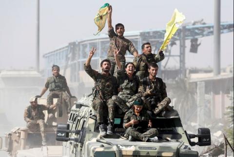 Syrian Democratic Forces (SDF) fighters ride atop of military vehicles as they celebrate victory in Raqqa, Syria, October 17, 2017. PHOTO BY REUTERS/Erik De Castro