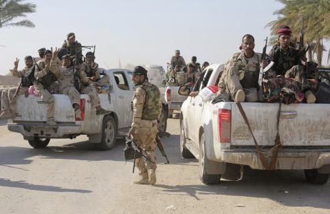 Shi'ite fighters and Iraqi army members ride in vehicles during a patrol in Jurf al-Sakhar, October 25, 2014. PHOTO BY REUTERS/Stringer