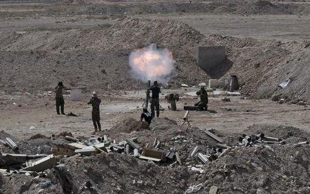 Members of the Iraqi army and Shi'ite fighters launch a mortar toward Islamic State militants outskirt the city of Falluja, Iraq, May 19, 2015. PHOTO BY REUTERS/Stringer