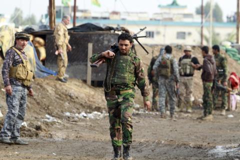A Shi'ite fighter walks during an intensive security deployment against Islamic State militants in Balad, north of Baghdad, December 15, 2014. PHOTO BY REUTERS/Mahmoud Raouf Mahmoud