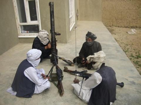 Taliban fighters pose with weapons as they sit in their compound at an undisclosed location in southern Afghanistan in this May 5, 2011 file picture. PHOTO BY REUTERS/Stringer