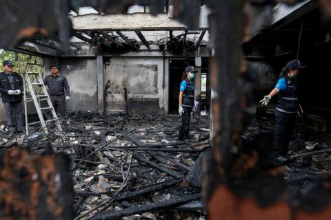Forensic exports inspect a burnt building at the Pitakkiat Wittaya School in the northern province of Chiang Rai, Thailand, May 23, 2016. PHOTO BY REUTERS/Athit Perawongmetha