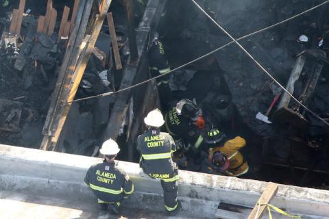 Firefighters work inside the burned warehouse following the fatal fire in the Fruitvale district of Oakland, California, U.S., December 4, 2016. PHOTO BY REUTERS/Lucy Nicholson
