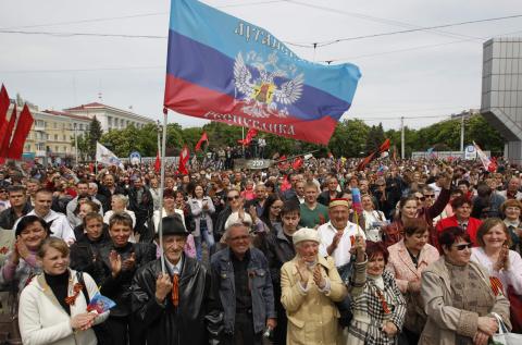 A man holds a flag, which reads "Lugansk Republic", during celebrations to mark Victory Day in the Eastern Ukrainian city of Lugansk