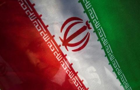A young boy stands behind an Iranian flag at Tehran's Mehrabad International Airport, Iran, May, 5, 2010. PHOTO BY REUTERS/Morteza Nikoubazl