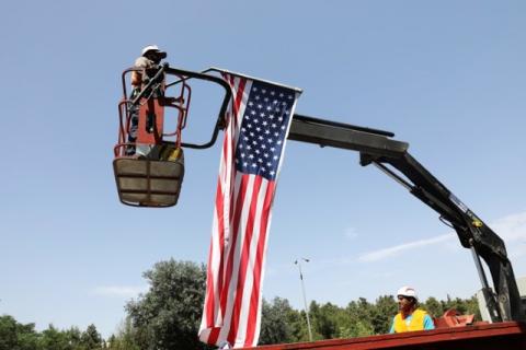 A labourer stands on a crane as he hangs an American flag to a street post, in preparation for the upcoming visit of U.S. President Donald Trump to Israel, in Jerusalem, May 18, 2017. PHOTO BY REUTERS/Ronen Zvulun