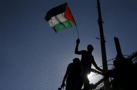 A spectator waves a Palestinian flag during the first leg of the Palestine Cup final soccer match between Gaza Strip's Shejaia and Hebron's Al-Ahly at al-Yarmouk stadium in Gaza City, August 6, 2015. PHOTO BY REUTERS/Mohammed Salem