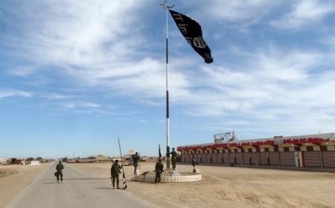 Iraqi security forces work on lowering the Islamic State flag, west of Ramadi, March 9, 2016. PHOTO BY REUTERS/Stringer