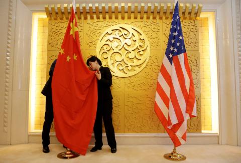 Staff members set up Chinese and U.S. flags for a meeting between Chinese Transport Minister Li Xiaopeng and U.S. Secretary of Transportation Elaine Chao at the Ministry of Transport of China in Beijing, China, April 27, 2018. PHOTO BY REUTERS/Jason Lee
