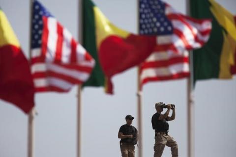 American security officers scan the airport from a rooftop below Senegalese and American flags before the departure of U.S. President Barack Obama in Dakar, Senegal, June 28, 2013. PHOTO BY REUTERS/Joe Penney