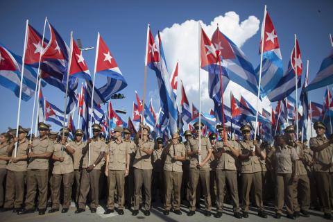 Members of the Cuban Revolutionary Army hold Cuban national flags during a march "For the Five and Against the Terrorism" in Havana, September 30, 2014. PHOTO BY REUTERS/Alexandre Meneghini