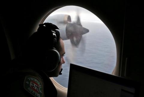 Flight officer Rayan Gharazeddine looks out of a Royal Australian Air Force (RAAF) AP-3C Orion as it flies over the southern Indian Ocean during the search for missing Malaysian Airlines flight MH370, March 22, 2014. PHOTO BY REUTERS/Rob Griffith