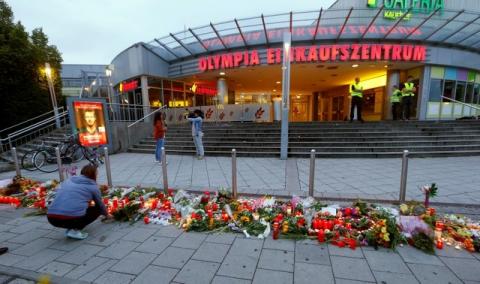 A woman lays flowers in front of the Olympia shopping mall, where yesterday's shooting rampage started, in Munich, Germany, July 23, 2016. PHOTO BY REUTERS/Arnd Wiegmann