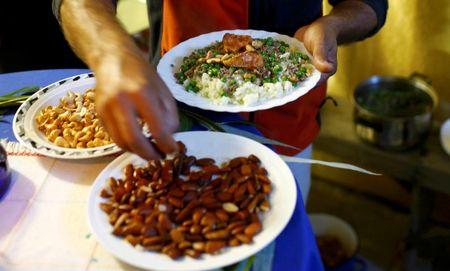 Finishing touches are made to Syrian dinners before being handed out, as refugees celebrate Eid al-Adha with Austrian villagers in the hall of Schloss Koenigshof, an ancient Habsburg castle in Bruckneudorf, Austria, September 24, 2015. PHOTO BY REUTERS/Leonhard Foeger