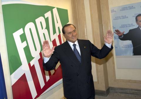 Former Italian leader Silvio Berlusconi stands inside the new headquarters of his re-launched original political party