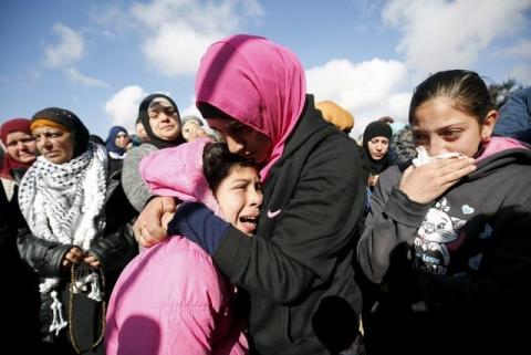 The daughter (L) of Palestinian woman Mahdia Hamad reacts during her funeral in Silwad near the West Bank city of Ramallah, December 26, 2015. PHOTO BY REUTERS/Mohamad Torokman