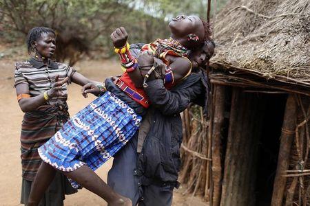 A man holds a girl as she tries to escape when she realised she is to to be married, about 80 km (50 miles) from the town of Marigat in Baringo County, December 7, 2014. PHOTO BY REUTERS/Siegfried Modola