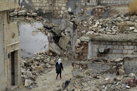 A school girl walks past damaged buildings in the rebel-controlled area of Maaret al-Numan town in Idlib province, Syria, October 28, 2015. PHOTO BY REUTERS/Khalil Ashawi