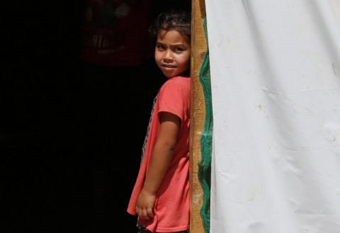 A Syrian refugee girl stands at the entrance of her tent at a camp for Syrian refugees near the town of Qab Elias, in Lebanon's Bekaa Valley, August 8, 2017. PHOTO BY REUTERS/Jamal Saidi