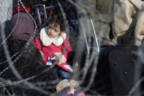 A Palestinian girl, hoping to cross into Egypt with her mother, is pictured through a fence as she waits at the Rafah crossing between Egypt and the southern Gaza Strip, December 21, 2014. PHOTO BY REUTERS/Ibraheem Abu Mustafa