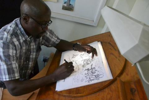 Cartoonist Godfrey Mwampembwa draws in his office in Kenya's capital Nairobi July 21, 2016. PHOTO BY REUTERS/Drazen Jorgic