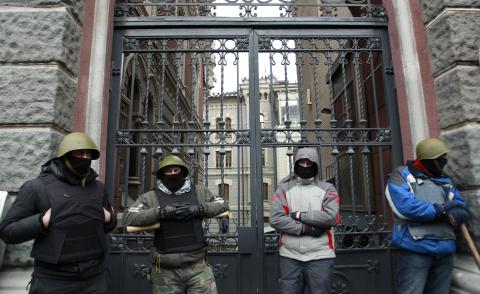 Anti-Yanukovich protesters stand guard at the national bank office in Kiev